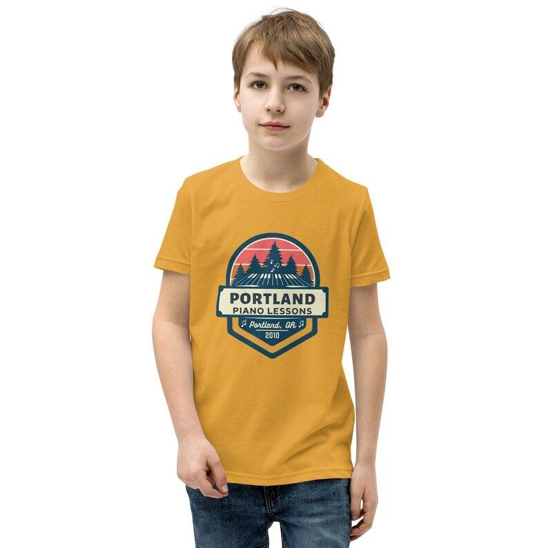 young boy wearing a yellow Portland Piano Lessons t-shirt