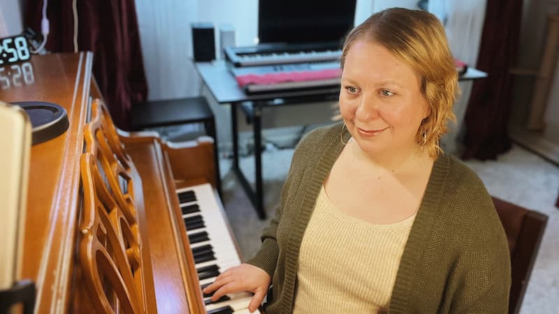 Sarah Collins at the piano in her home studio