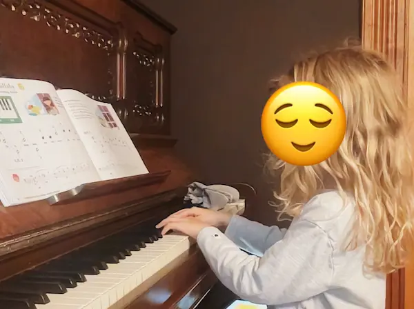 A student plays piano during an online lesson