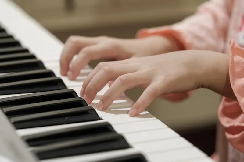 A student smiles during an online piano lesson