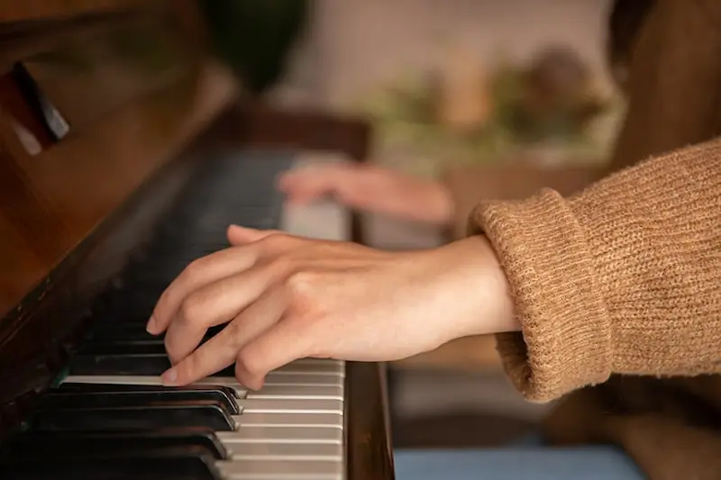 close up of hands playing piano during an online piano lesson